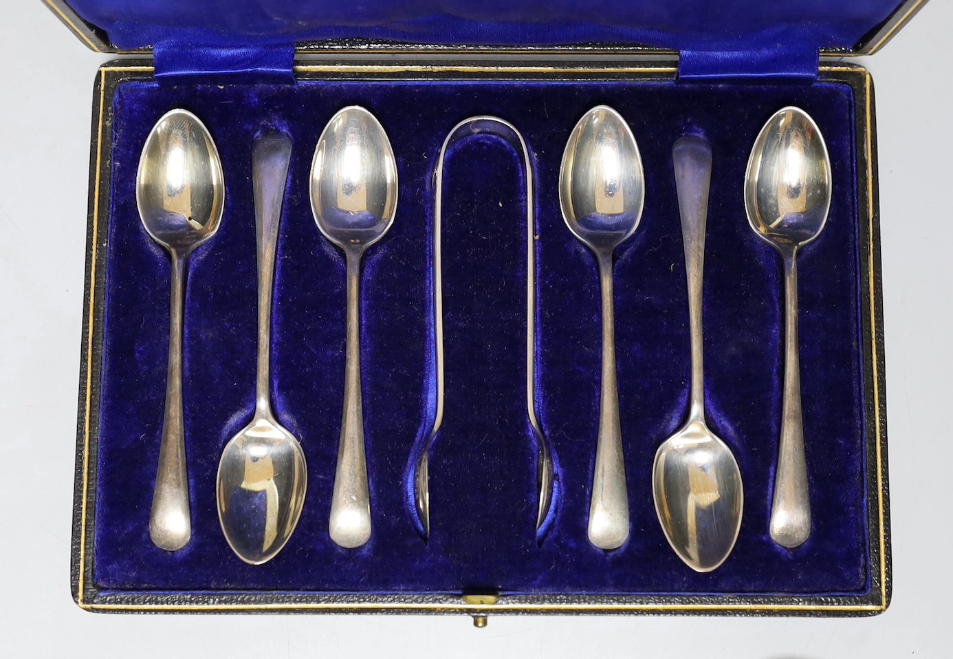 A cased set of six George V silver teaspoons, with sugar tongs and seven other items of silver or white metal flatware.
